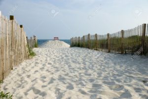1260926-sandy-path-to-beach-with-lifeguard-chair-in-background-stock-photo